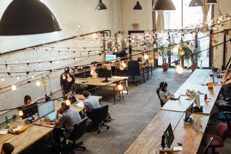 Postazioni e persone al lavoro in uno spazio di coworking