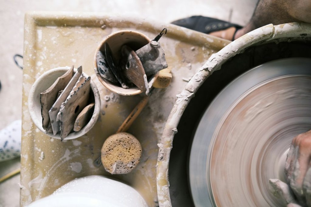 Mani che modellano l'argilla su un tornio da ceramica